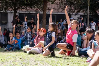 3 girls at STEM Girl Day raising hands during the Physics Circus 