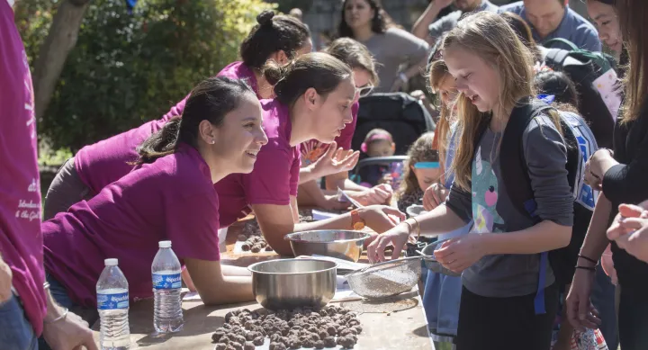STEM Girl Day outdoors activity booth with volunteers and participants
